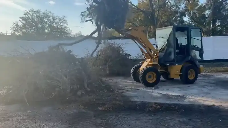 Wheel loader pushing a pile of cleared brush and roots on a land clearing job